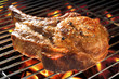 Grilled pork chop on flaming grill.