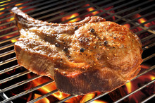 Grilled Pork Chop On Flaming Grill.