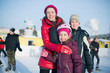 © Pavel Losevsky - A mother with two children standing on outdoor rink