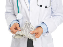 Closeup On Doctor Counting Dollars