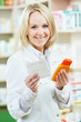 © Kadmy - Happy pharmacist woman in pharmacy shop