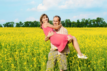 Happy man and woman in yellow meadow