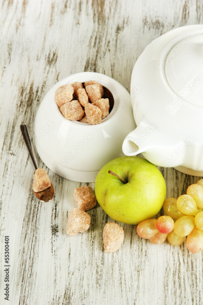 Unrefined sugar in white sugar bowl on wooden background