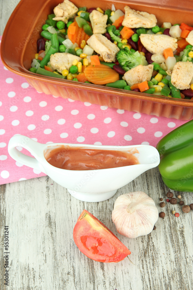 Casserole with vegetables and meat, on wooden background