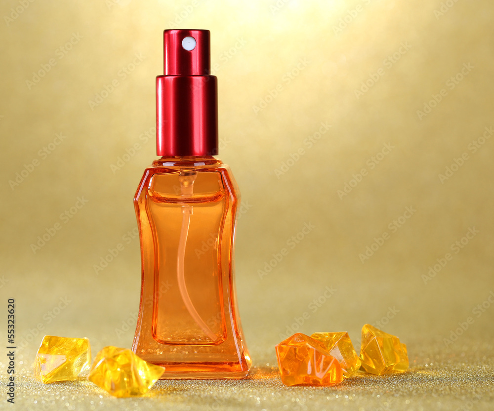 Women perfume in beautiful bottle on orange background