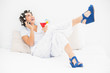 © lightwavemedia - Brunette in hair rollers and wedge shoes holding a cocktail maki