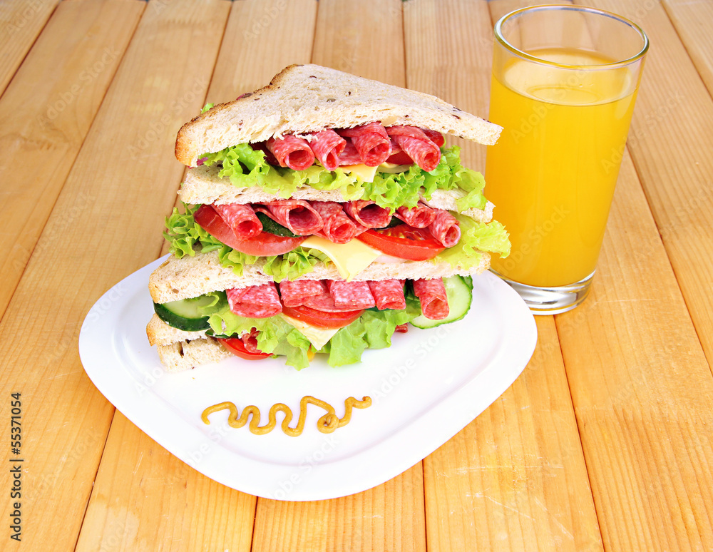 Huge sandwich on wooden table, on wooden background