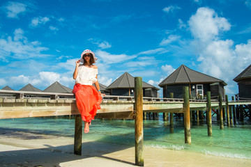 Wall Mural - The girl on a wooden bridge near the water bungalows (Maldives -