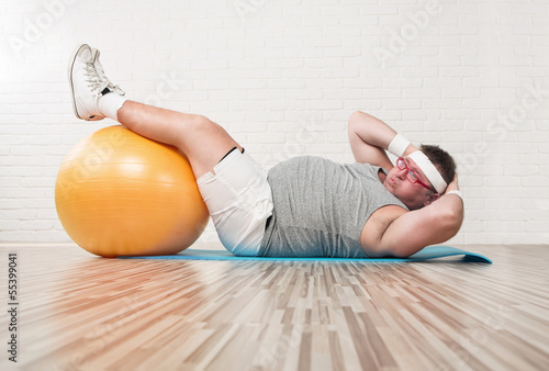 Fotomural Hombre con sobrepeso divertido hacer ejercicio en el gimnasio