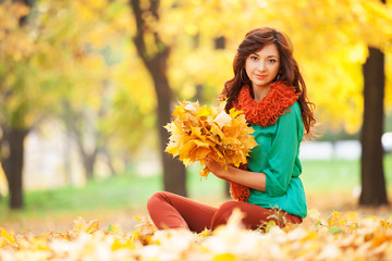 Wall Mural - Young pretty woman relaxing in the autumn park