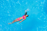 Fototapeta  - A girl is relaxing in a swimming pool