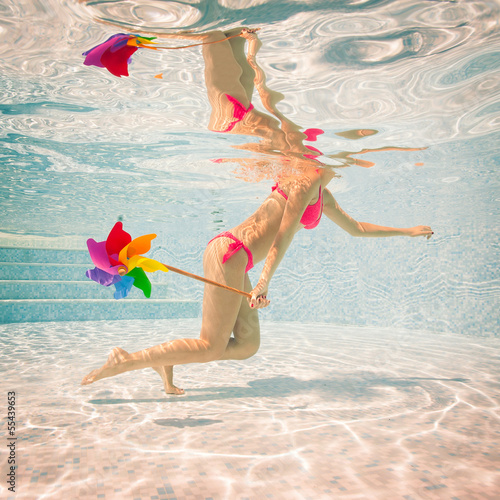 Naklejka samoprzylepna Portret dziewczyny pod wodą z różowym bikini i wiatrak w swimmi