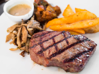 Rib eye steak meal with french fries and mushroom