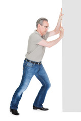 Portrait of mature man pushing placard