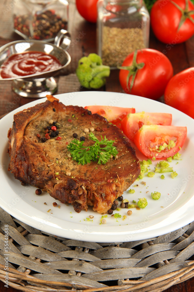 Piece of fried meat on plate on wooden table close-up