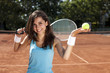 Young girl holding tennis ball on court