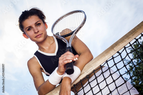 Beautiful young girl rests on a tennis net Poster