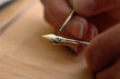 Closeup: Hand mit Pinsel bemalt goldene Füllerfeder