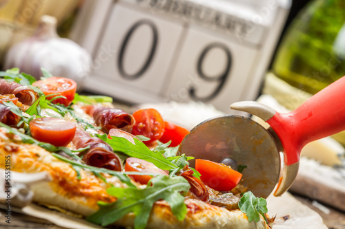 Naklejka samoprzylepna Cięcie pieczonej pizzy w tle z kalendarza