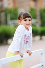 cute little girl smiling in a park close-up