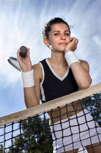 Beautiful young girl rests on a tennis net Tableau sur Toile