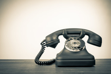Fototapete - Retro rotary telephone on table for vintage background