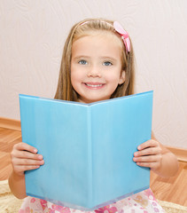 Wall Mural - Cute little girl reading a book