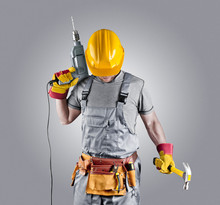 Builder In A Helmet With A Hammer And A Drill