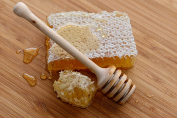 Honey and wooden spoon on wooden background