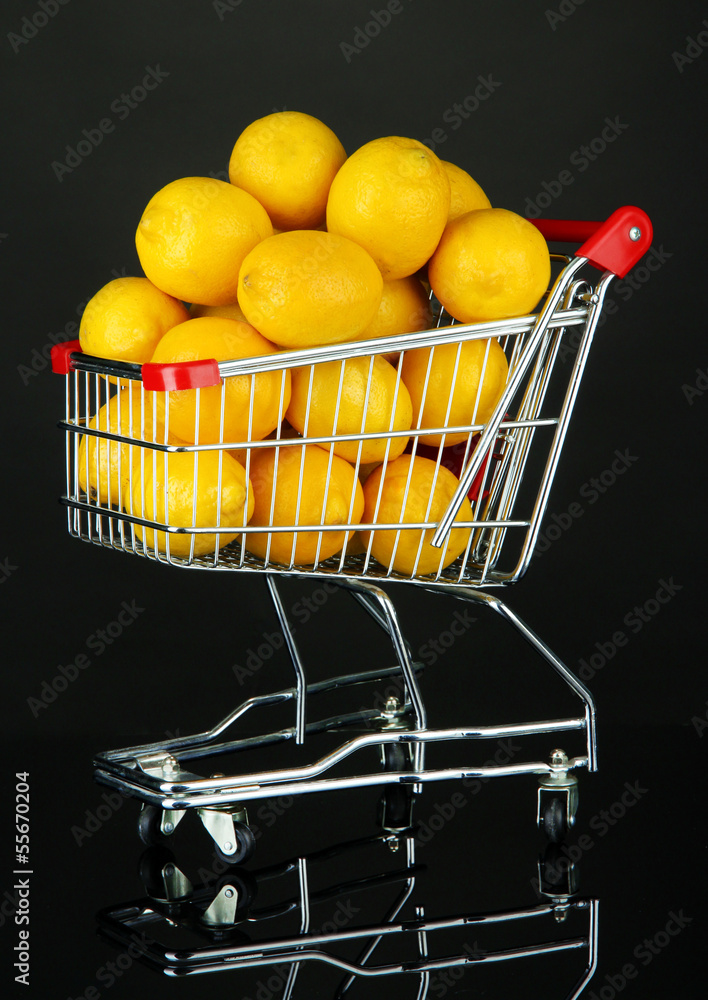 Ripe lemons in trolley isolated on black