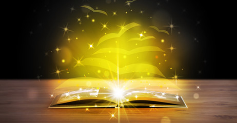 Open book with golden glow flying paper pages