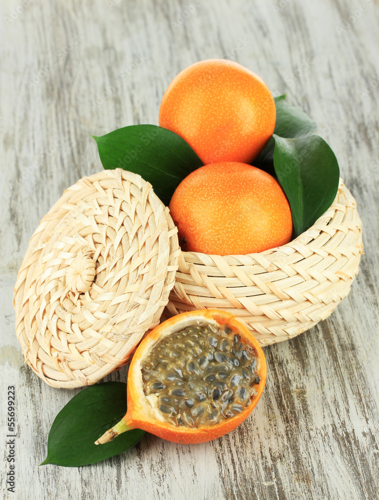 Passion fruits in wicker basket on table close-up