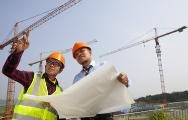 Canvas Print - Young asian architects discussion front of construction site