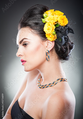 Fototapeta na wymiar Beautiful female art portrait with yellow roses in her hair