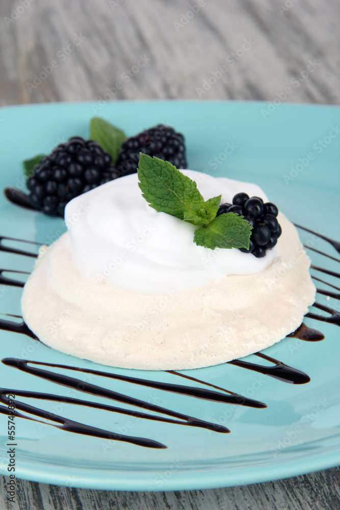 Tasty meringue cake with berries on wooden table