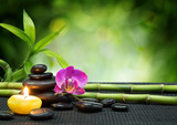 purple orchid, candle, with stones , bamboo on black mat