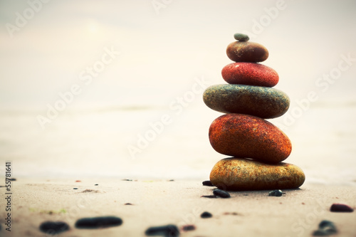 Fototapeta na wymiar Stones pyramid on sand symbolizing zen, harmony, balance