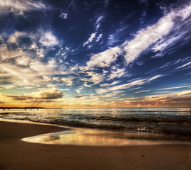 Calm ocean under dramatic sunset sky