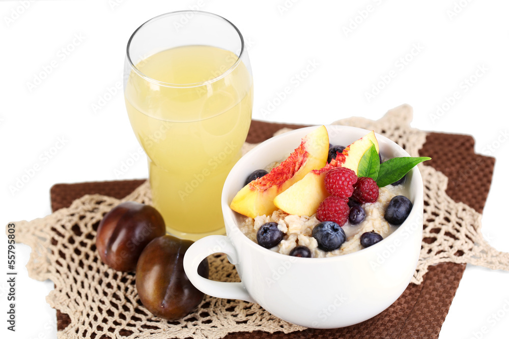 Oatmeal in cup with berries on napkins isolated on white