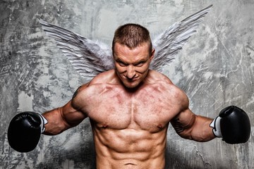 Young boxer with angel wings behind his back