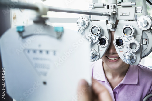 Cuadros en Lienzo Close-up of optometrist doing an eye exam on young woman