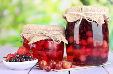 Wall Mural - Home made berry jam on wooden table on bright background