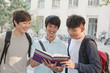 © xixinxing - Three students discussing and looking at the book