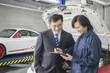 © xixinxing - Businessman with Mechanic in Auto Repair Shop