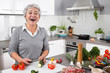 Seniorin - ältere Frau hat Spaß beim Kochen - Gemüse