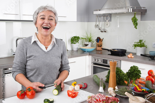 Foto Seniorin - ältere Frau hat Spaß beim Kochen - Gemüse