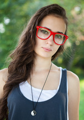 Wall Mural - Beautiful girl withred glasses in the park