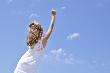 hand of a young girl on a background of the sky greets the new d