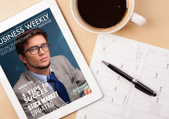 Wall Mural - tablet pc showing magazine on screen with a cup of coffee on a d