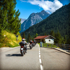 Fotobehang - group of bikers on the road in alps